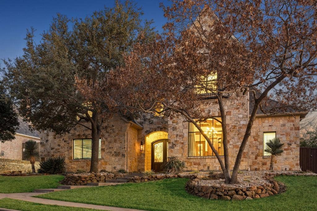 6640 Briar Ridge Lane, Plano, TX 75024 Stone exterior with arched entry, multi-pane windows, and a prominent front gable
