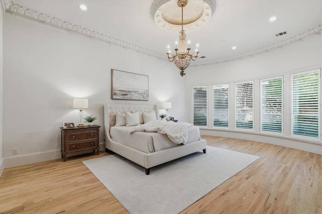 A wall of windows fills the generously scaled primary suite with natural light and beautiful pool views.