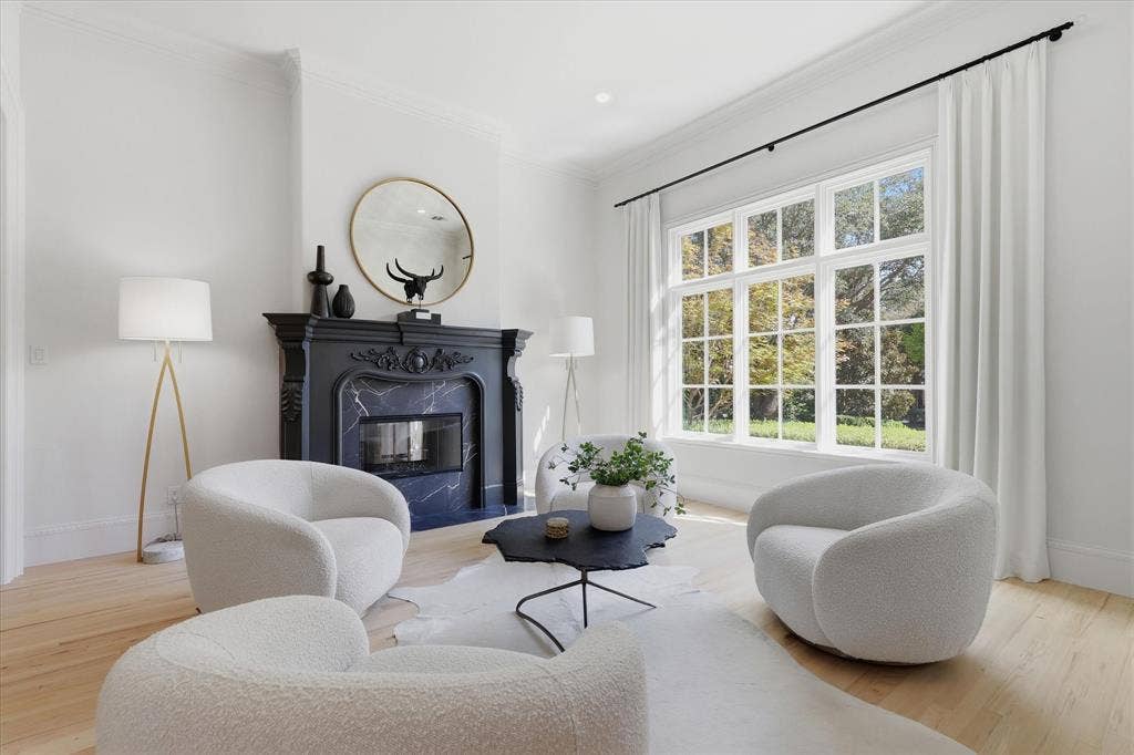 An intimate formal living room pairs garden views with a richly detailed fireplace.