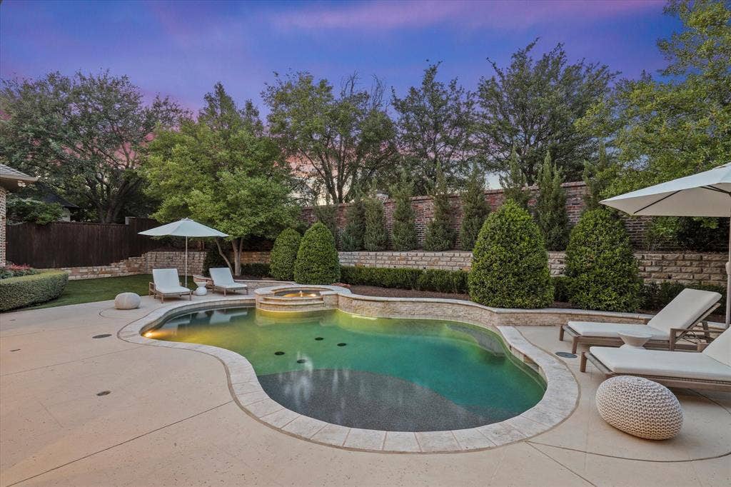 The updated PebbleTec pool is framed by new decking, a stone feature wall and mature landscaping for the ultimate privacy.