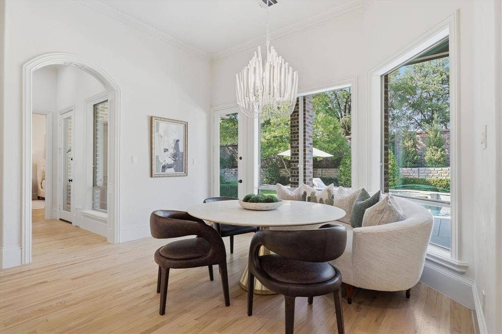 The spacious breakfast area is wrapped in windows overlooking the pool and backyard.