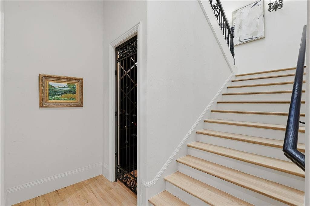 The dedicated wine cellar is discreetly tucked beneath the staircase behind an ornamental iron door.