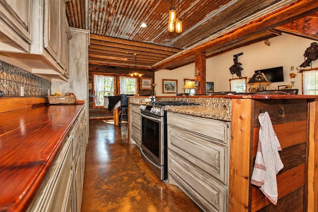 7245 County Road 4095, Kaufman, TX 75142 Kitchen with wood-finish countertops, grey cabinetry, stainless steel range, textured tile backsplash, and a corrugated metal ceiling