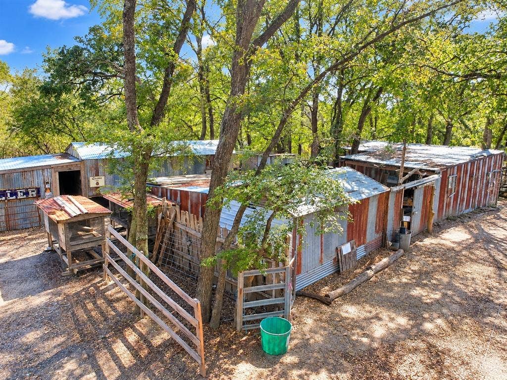 7245 County Road 4095, Kaufman, TX 75142 Multiple outbuildings with corrugated metal siding, wood fencing, and mature trees