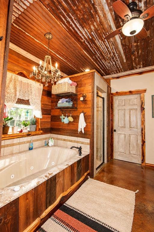7245 County Road 4095, Kaufman, TX 75142 Jetted soaking tub with wood-finish paneling, tiled surround, and dark bronze fixtures