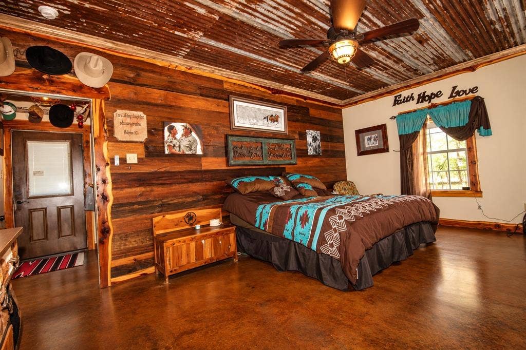7245 County Road 4095, Kaufman, TX 75142 Wood-paneled wall, corrugated metal ceiling, ceiling fan with integrated lighting, wood-finish flooring, and a large window providing natural illumination