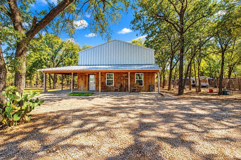 7245 County Road 4095, Kaufman, TX 75142 Wood-sided structure with a metal roof and an extended covered porch