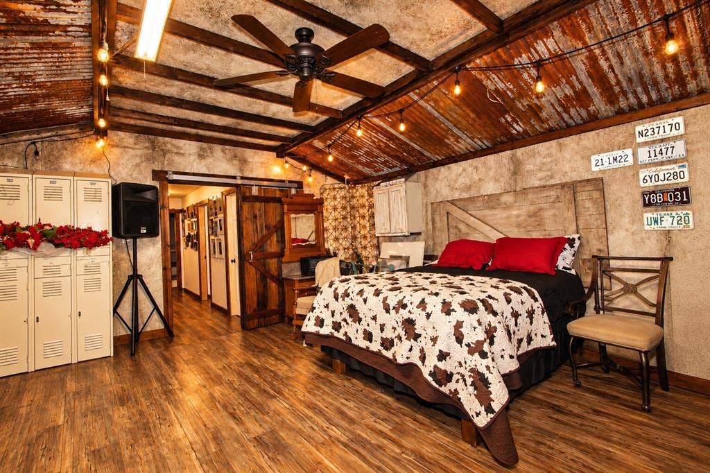 7245 County Road 4095, Kaufman, TX 75142 Kitchen featuring a corrugated metal ceiling, wood-finish flooring, custom cabinetry with a distressed finish, a center island with a wood base, and a tiled backsplash