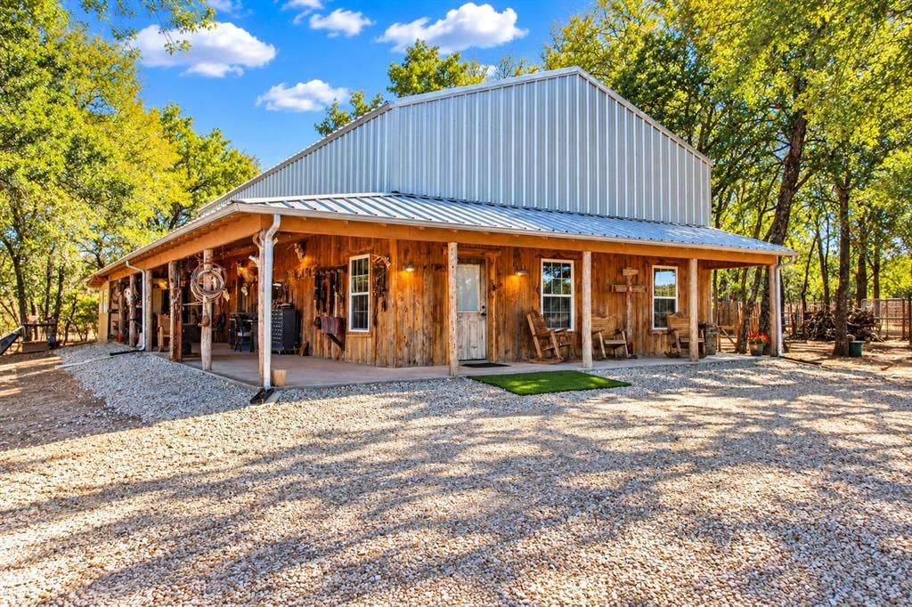 7245 County Road 4095, Kaufman, TX 75142 Exterior featuring a metal roof, wood siding, and an expansive covered porch