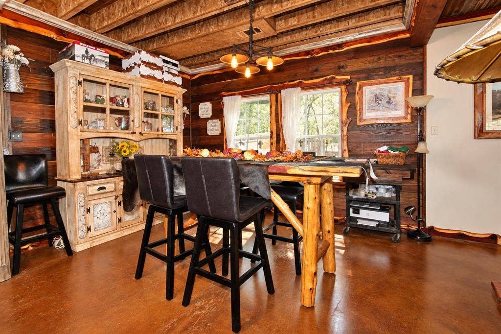 7245 County Road 4095, Kaufman, TX 75142 Wood-finish flooring, exposed wood beam ceiling, wood-paneled walls, built-in display hutch, and multiple windows