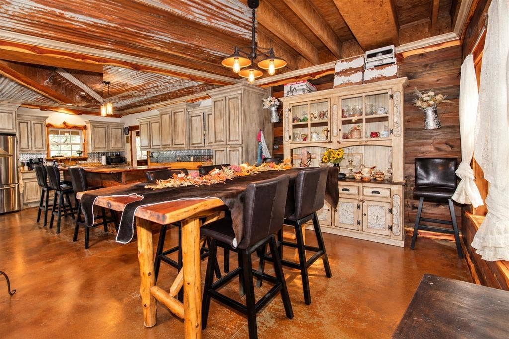 7245 County Road 4095, Kaufman, TX 75142 Wood plank walls, wood-finish flooring, wood beam ceiling, exposed corrugated metal ceiling, and built-in cabinetry