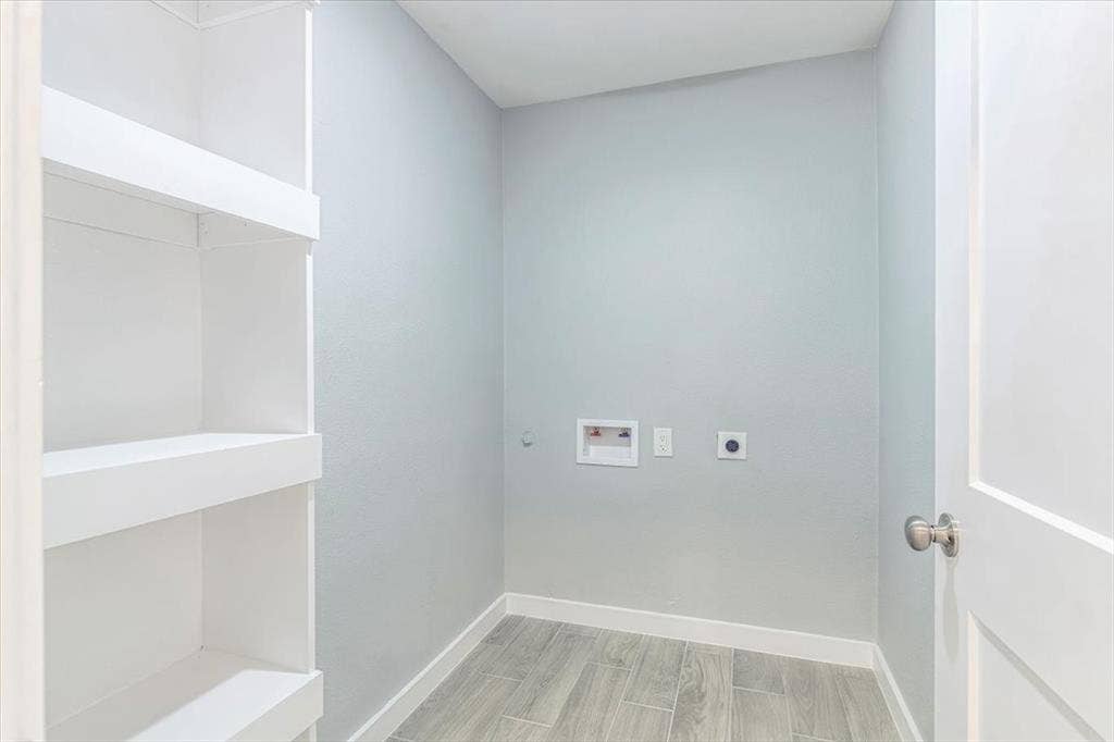 12326 Dandridge Drive, Dallas, TX 75243 Built-in shelving, light gray wall finish, wood-finish flooring, white door, and brushed nickel hardware