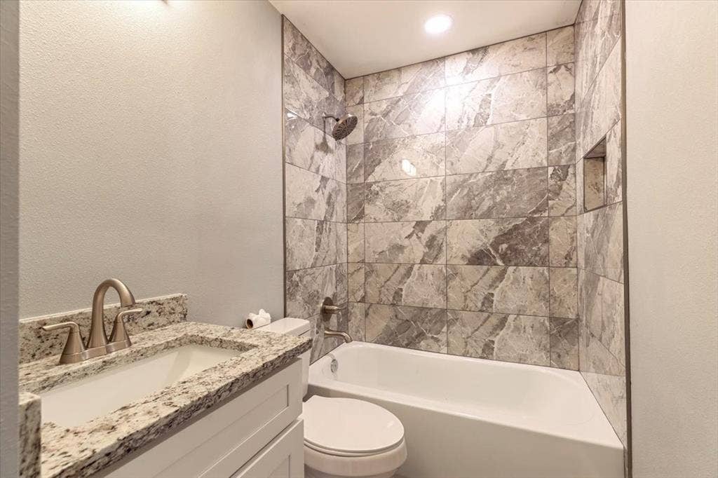 12326 Dandridge Drive, Dallas, TX 75243 Bathroom featuring a white vanity with a light granite countertop, an undermount sink, and brushed nickel fixtures