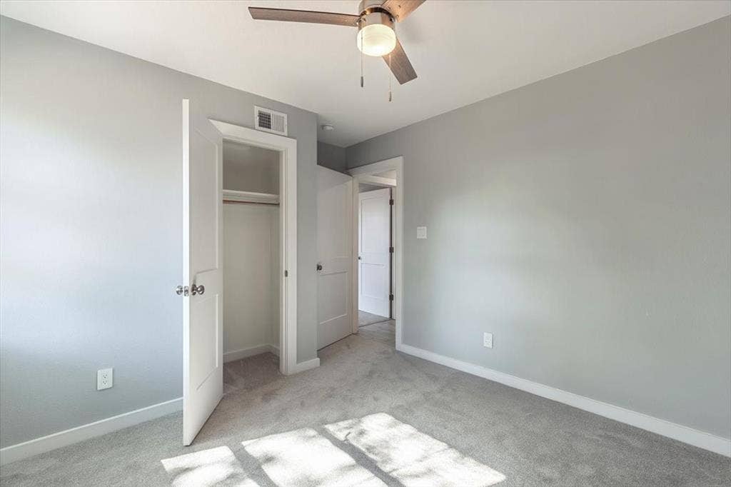 12326 Dandridge Drive, Dallas, TX 75243 Neutral tone walls with white trim, ceiling fan with integrated lighting, soft grey carpeting, and closet with built-in rod
