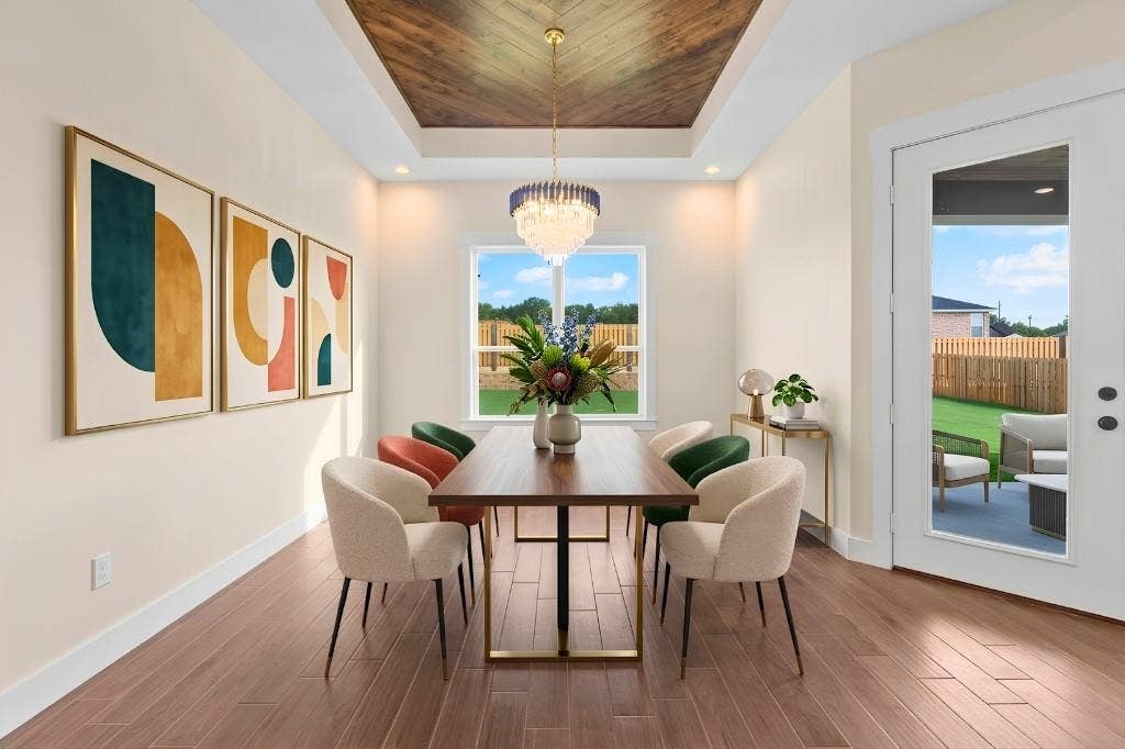 Wood-finish flooring throughout, tray ceiling with wood-finish inlay, and a chandelier with blue and gold accents