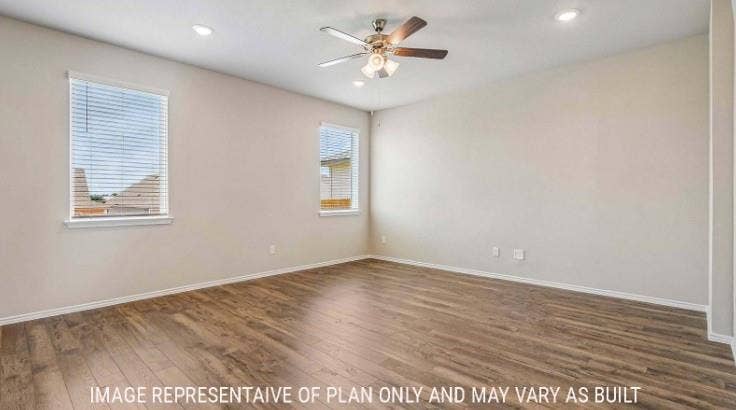 Wood-finish flooring, two windows with blinds, recessed lighting, and a ceiling fan with integrated light