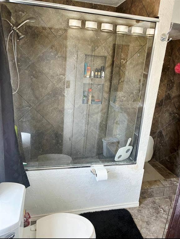 3009 Plumtree Lane, Plano, TX 75074 Glass-enclosed shower with tiled walls and built-in shelving