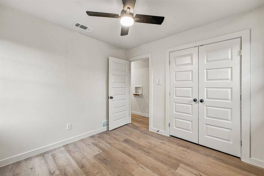 13706 Janwood Lane, Farmers Branch, TX 75234 Neutral-toned interior featuring wood-finish flooring, a ceiling fan with integrated lighting, and five-panel interior doors