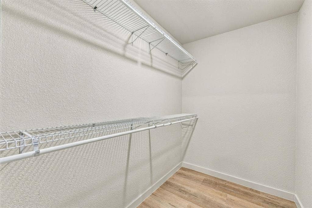 13706 Janwood Lane, Farmers Branch, TX 75234 Storage area featuring dual-tier white wire shelving and wood-finish flooring