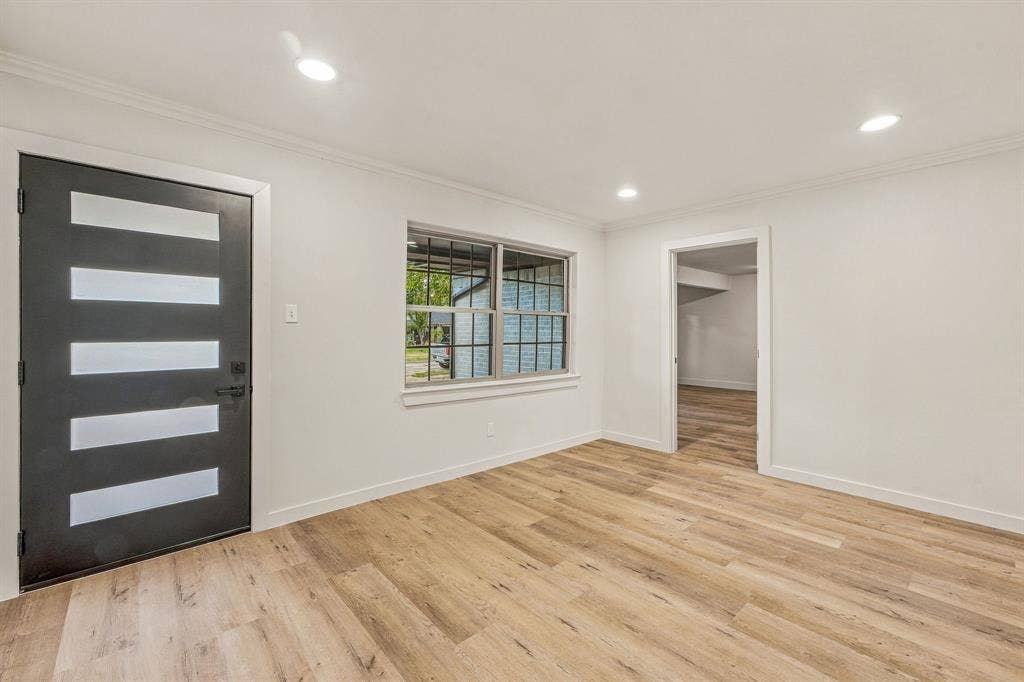 13706 Janwood Lane, Farmers Branch, TX 75234 Modern entryway featuring wood-finish flooring, a contemporary front door with horizontal frosted glass insets, recessed ceiling lighting, and a multi-pane window