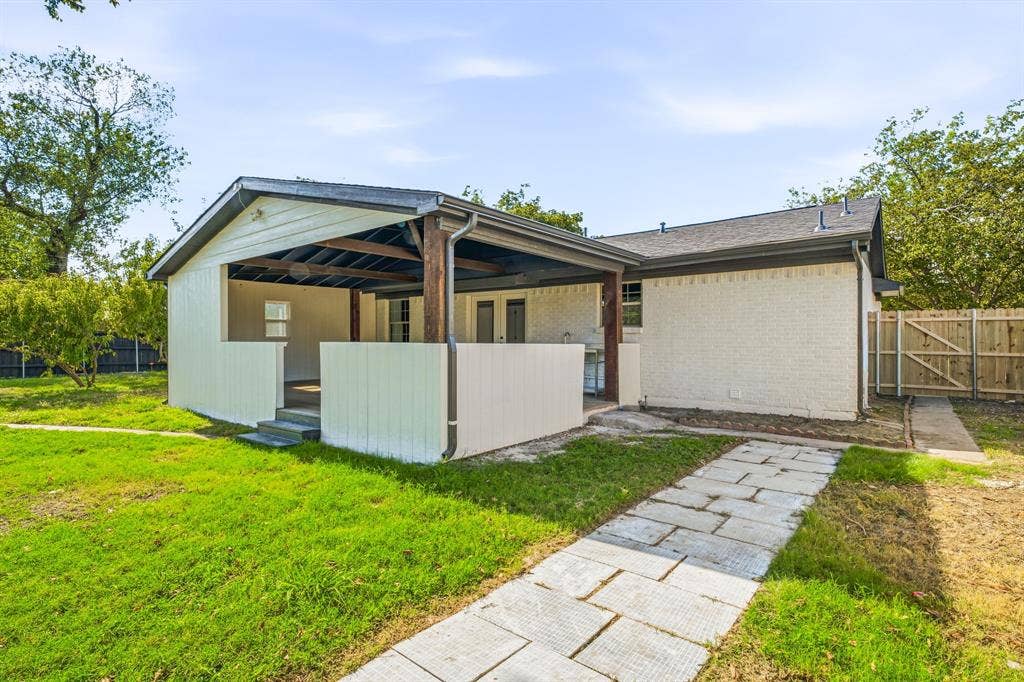 13706 Janwood Lane, Farmers Branch, TX 75234 Covered patio with wood-beam ceiling, brick exterior, stone paver walkway, and wooden privacy fencing