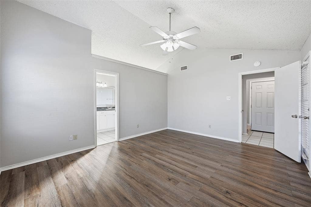 6421 Fairview Drive, Watauga, TX 76148 Vaulted ceiling with a ceiling fan, wood-finish flooring, and light gray wall paint