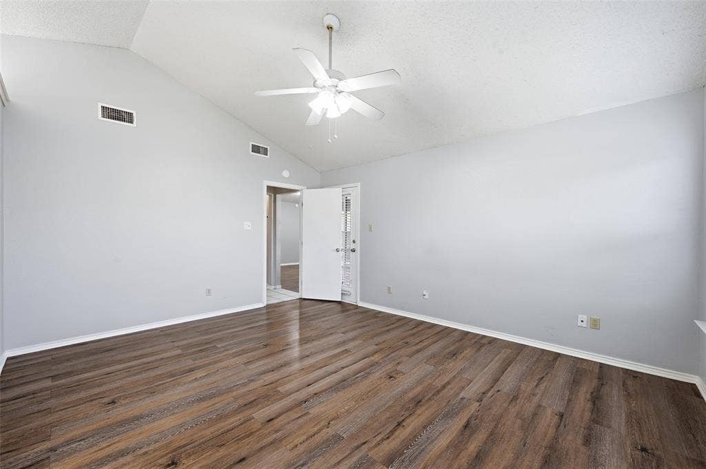 6421 Fairview Drive, Watauga, TX 76148 Vaulted ceiling with a white ceiling fan, wood-finish flooring, and light-toned walls