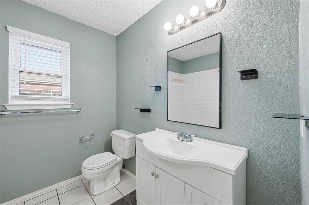 6421 Fairview Drive, Watauga, TX 76148 White vanity with integrated sink, rectangular mirror, and overhead vanity lighting