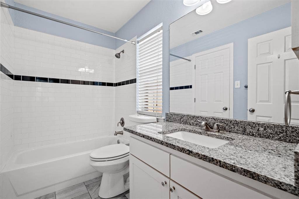 14592 Aspen Court, Addison, TX 75001 White subway tile shower surround with a black accent band