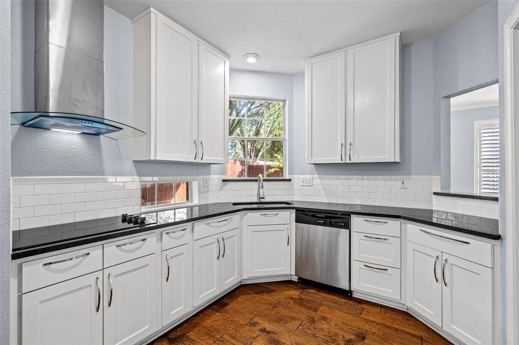 14592 Aspen Court, Addison, TX 75001 White cabinetry, dark countertops, a stainless steel dishwasher, and wood-finish flooring