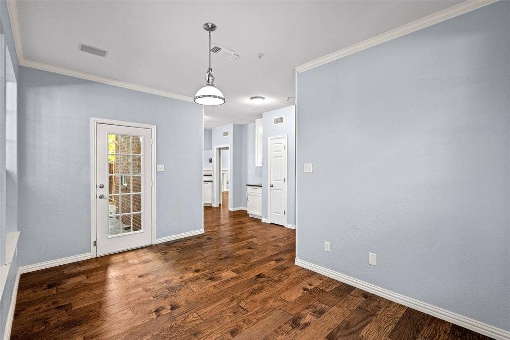 14592 Aspen Court, Addison, TX 75001 Wood-finish flooring throughout, white crown molding, and a paneled glass door