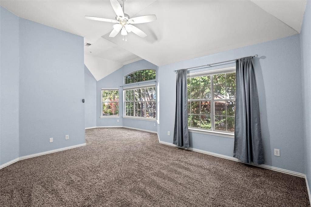 14592 Aspen Court, Addison, TX 75001 Vaulted ceilings, a ceiling fan, and multiple windows with an arched transom window