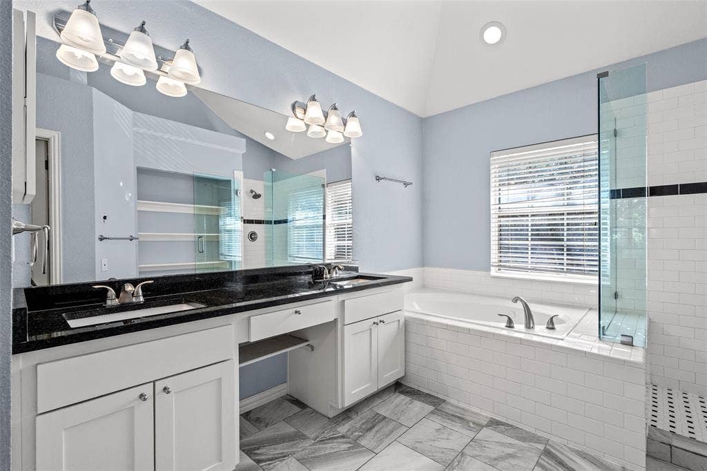 14592 Aspen Court, Addison, TX 75001 Dual vanity with undermount sinks, black countertop, and white cabinetry