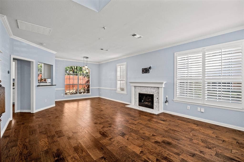 14592 Aspen Court, Addison, TX 75001 Hardwood flooring, fireplace with tile surround, white plantation shutters, crown molding, and recessed lighting