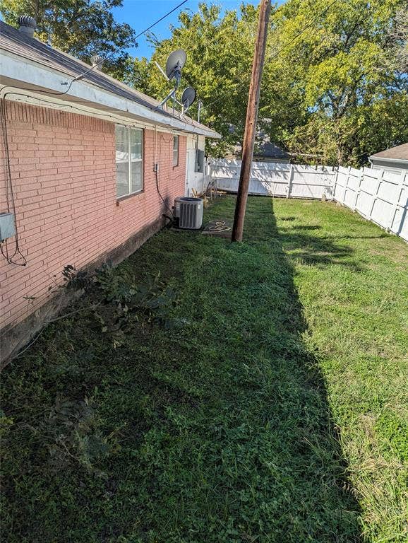 111 Murchison Street, Farmersville, TX 75442 Fenced backyard with a grassy lawn and mature shade trees, offering outdoor space with plenty of potential for landscaping, gardening, or creating your own backyard retreat!