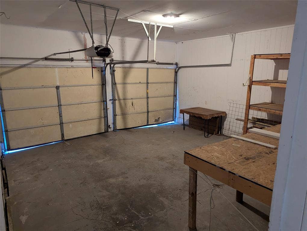 111 Murchison Street, Farmersville, TX 75442 Spacious 2-car garage with overhead door, workbench, and shelving. Plenty of room for tools, projects, and storage!