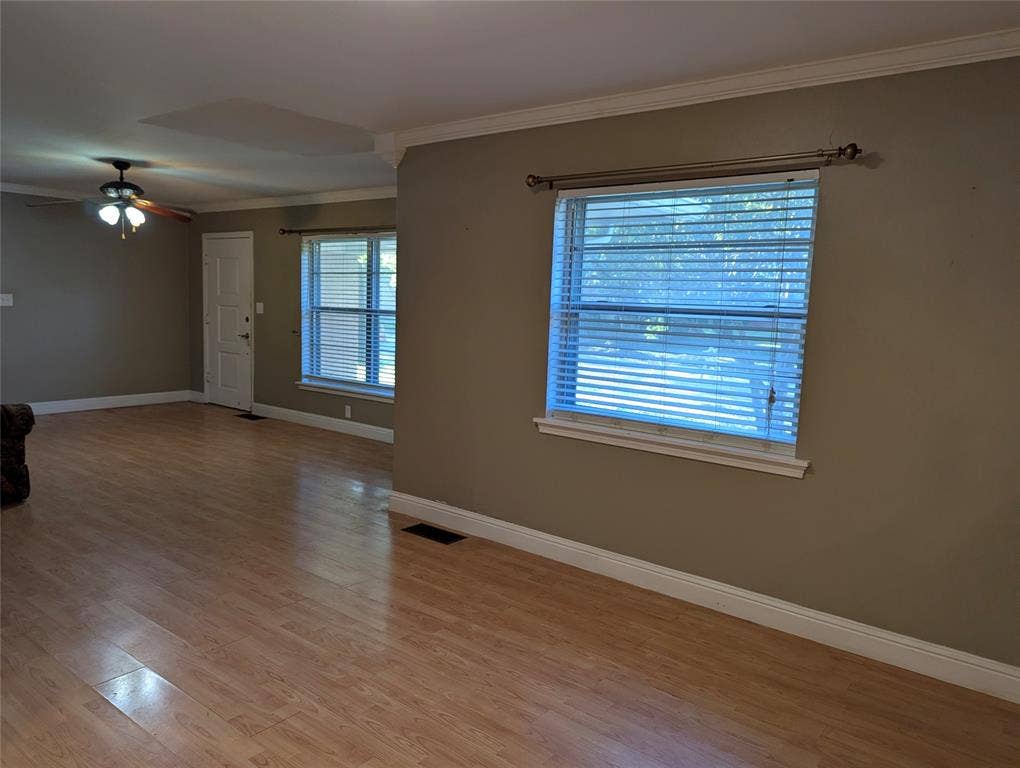 111 Murchison Street, Farmersville, TX 75442 Open & Spacious living and dining rooms featuring wood-look flooring, neutral wall colors, crown molding and large windows welcomes natural light, creating a comfortable space ready for your personal touches!