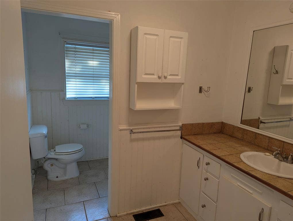 111 Murchison Street, Farmersville, TX 75442 Full bathroom located between Bedrooms #2 and #3, featuring a vanity, built-in cabinetry, and an opportunity for a complete makeover.