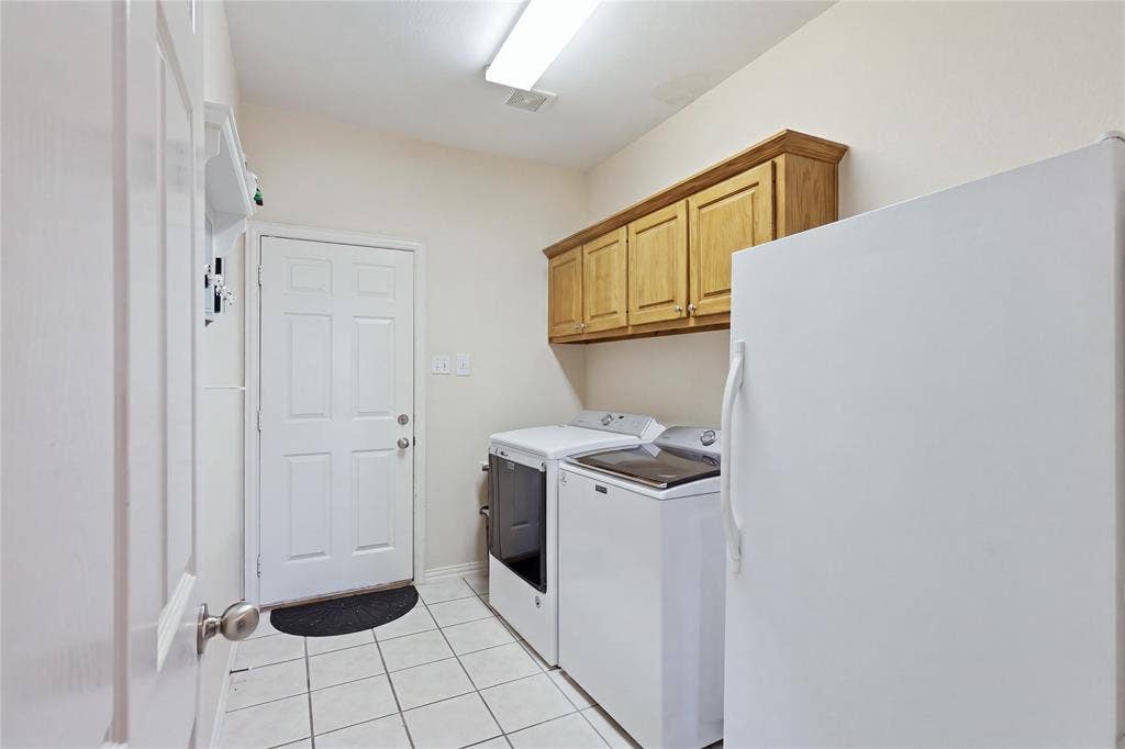 1926 Vintage Drive, Corinth, TX 76210 White tile flooring, wood-finish upper cabinetry, and a panel door