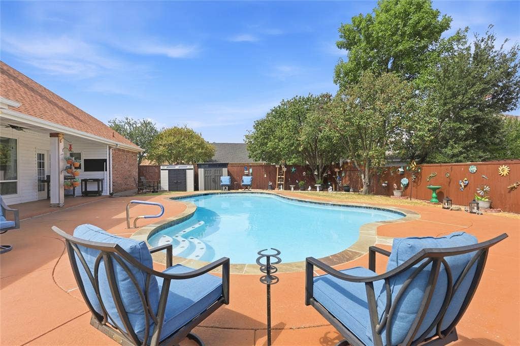 1926 Vintage Drive, Corinth, TX 76210 Outdoor swimming pool with integrated steps, surrounded by an expansive concrete patio and a privacy fence