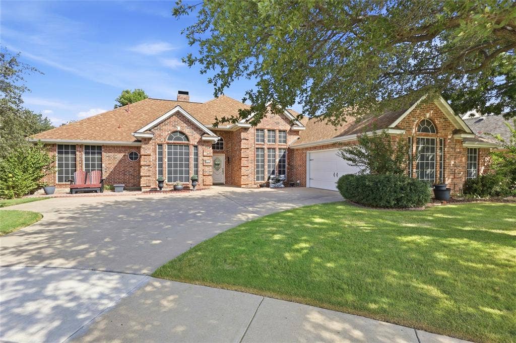 1926 Vintage Drive, Corinth, TX 76210 Brick exterior with a prominent arched window, multi-paned windows, and a large driveway