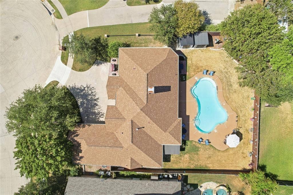 1926 Vintage Drive, Corinth, TX 76210 Spacious property featuring a large house with a shingle roof, a backyard swimming pool, and a storage shed