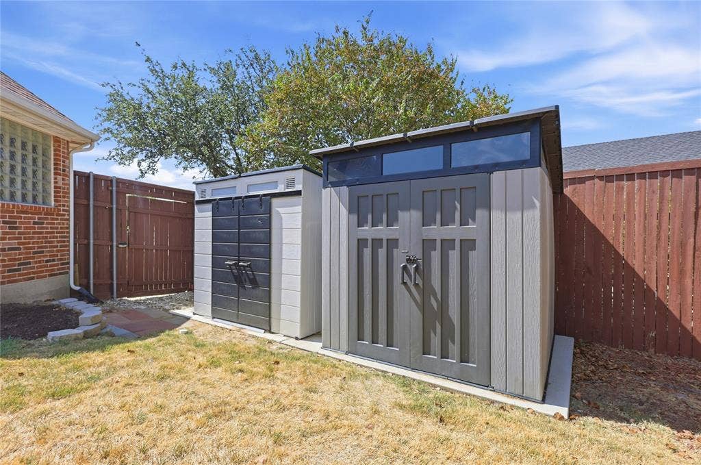 1926 Vintage Drive, Corinth, TX 76210 Two storage sheds with a wood-look finish, featuring transom windows and double doors