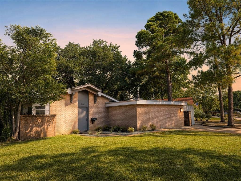 3401 Hanover Lane, Irving, TX 75062 Brick exterior with a prominent entry, mature trees, and an expansive lawn