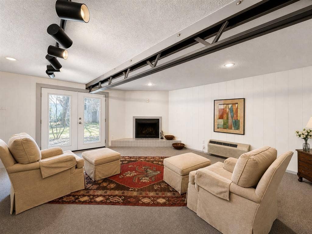 3401 Hanover Lane, Irving, TX 75062 Corner fireplace with tile hearth, recessed lighting, track lighting, exposed ceiling beam, and French doors