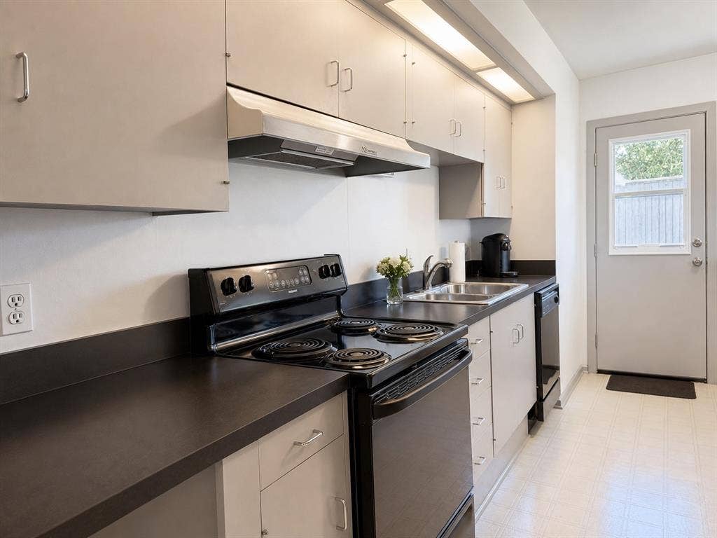 3401 Hanover Lane, Irving, TX 75062 Kitchen featuring a full suite of black appliances, double basin stainless steel sink, ample cabinetry, and durable countertops