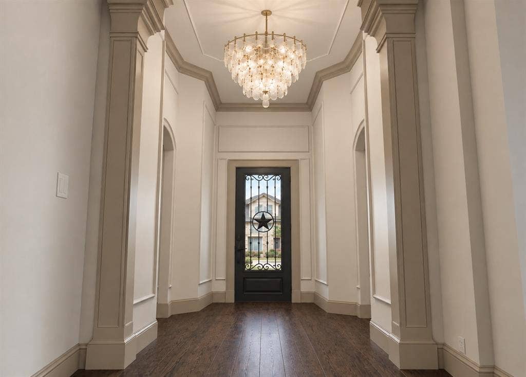 409 Saratoga Drive, Denton, TX 76210 A Texas-sized iron door opens to a stately foyer with soaring 14’ ceilings, statement lighting, graceful arches, and curated millwork, creating a striking intro to the breathtaking open-concept living space where engineered hardwood floors flow throughout the main areas.Rendering Disclaimer: Images are artist renderings intended to illustrate the anticipated finished home. Final finishes, materials, colors, fixtures, landscaping, and other details are subject to change.