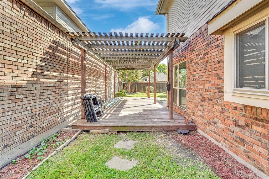 1920 Keystone Drive, Plano, TX 75075 Wood pergola covering a wood deck with brick exterior walls and a grassy area
