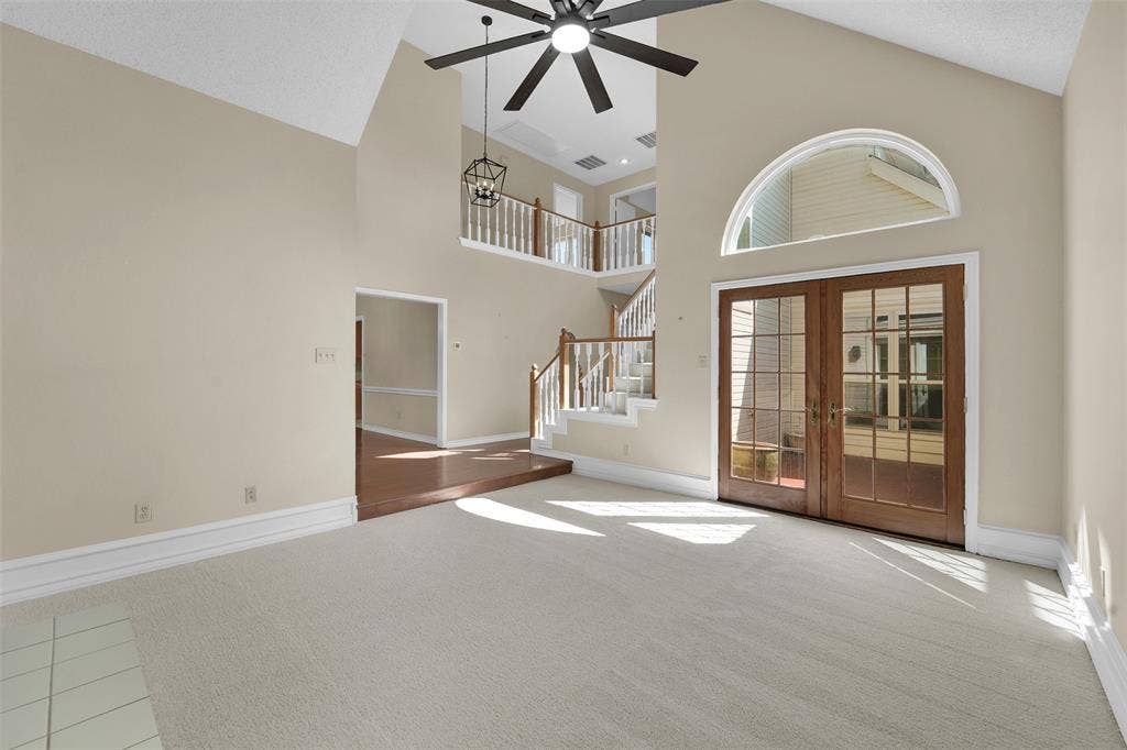 1920 Keystone Drive, Plano, TX 75075 Vaulted ceilings, a dark wood-finish ceiling fan, and a light-colored carpeted floor