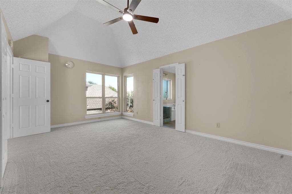 1920 Keystone Drive, Plano, TX 75075 Vaulted ceiling with a ceiling fan, light-toned carpeting, ample natural light, and a bi-fold door entryway